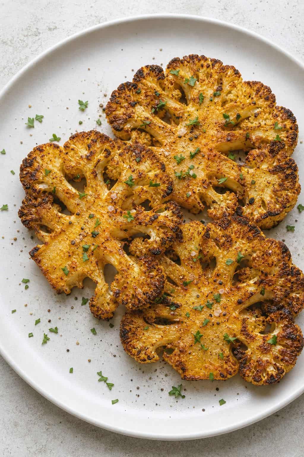Air Fryer Cauliflower Steaks Recipe (Crispy, 20 Minutes) Air fryer cauliflower steaks with crispy paprika edges, parsley, smoked salt, and black pepper