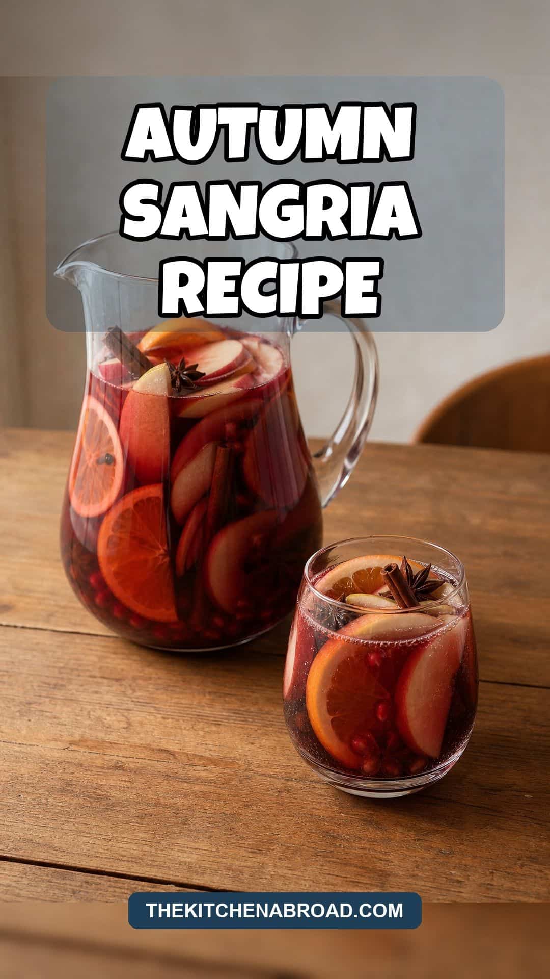 Autumn Sangria Recipe Pinterest pin for autumn sangria recipe with a pitcher and glass of red sangria with apples oranges pomegranate and warm spices