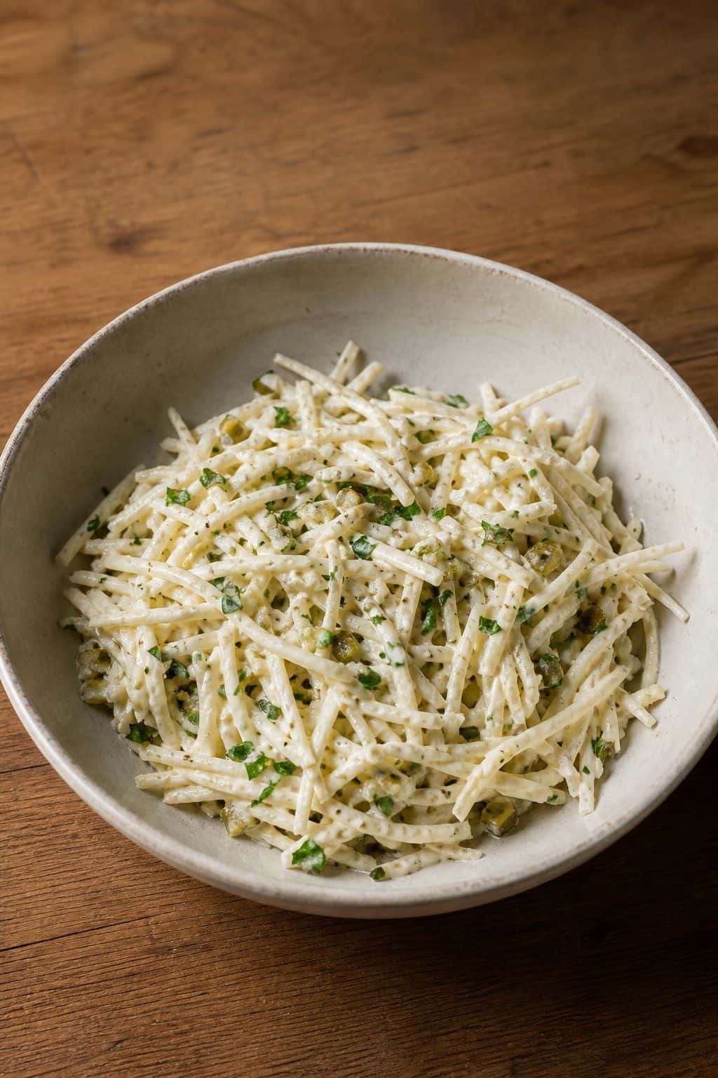 Creamy celeriac salad with fine raw celeriac matchsticks, Dijon dressing, parsley, cornichon, and black pepper.