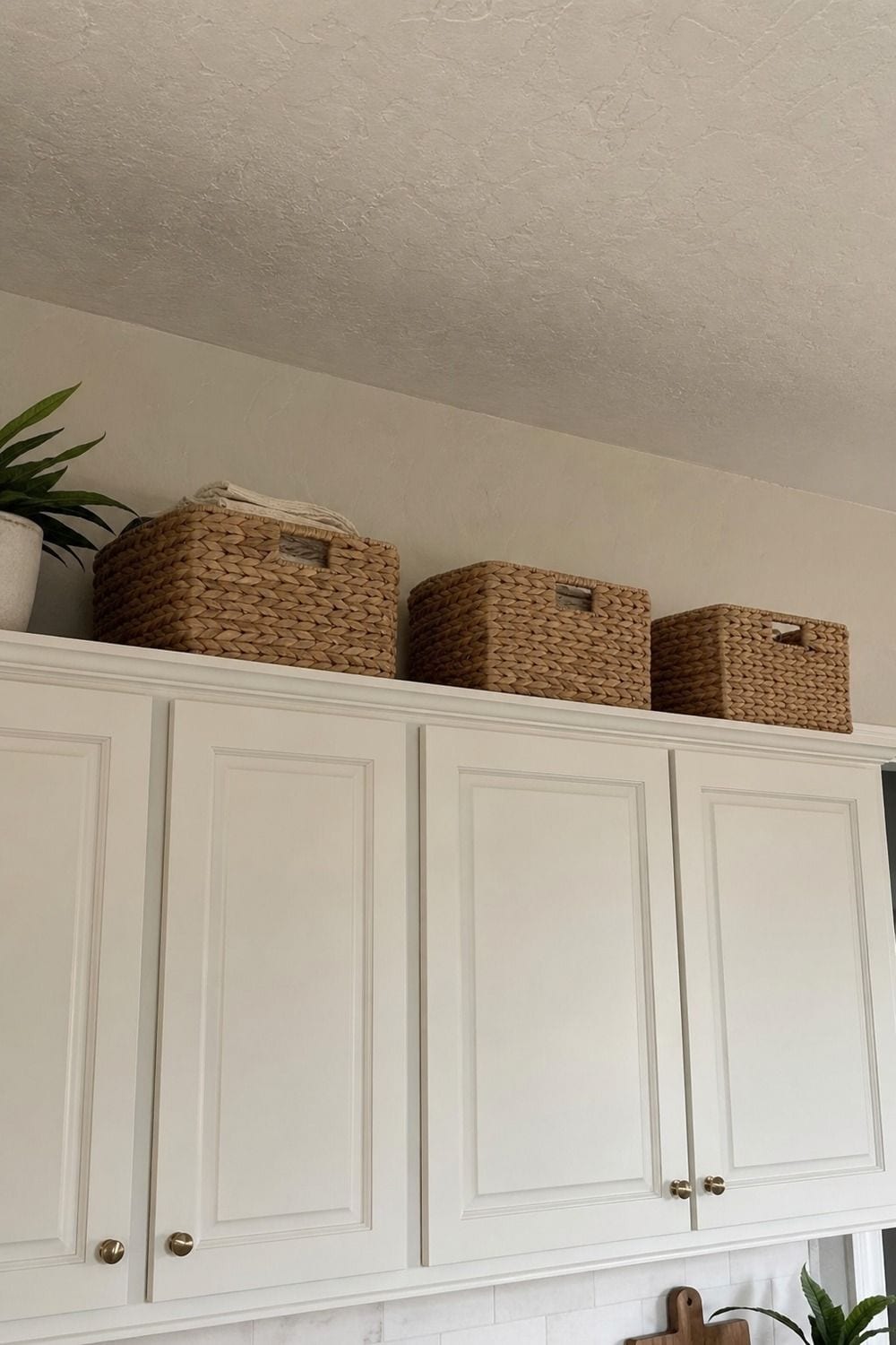 25 Coastal Kitchen Ideas for a Beautiful Kitchen Seagrass Storage Baskets Above Cabinets in a casual coastal kitchen