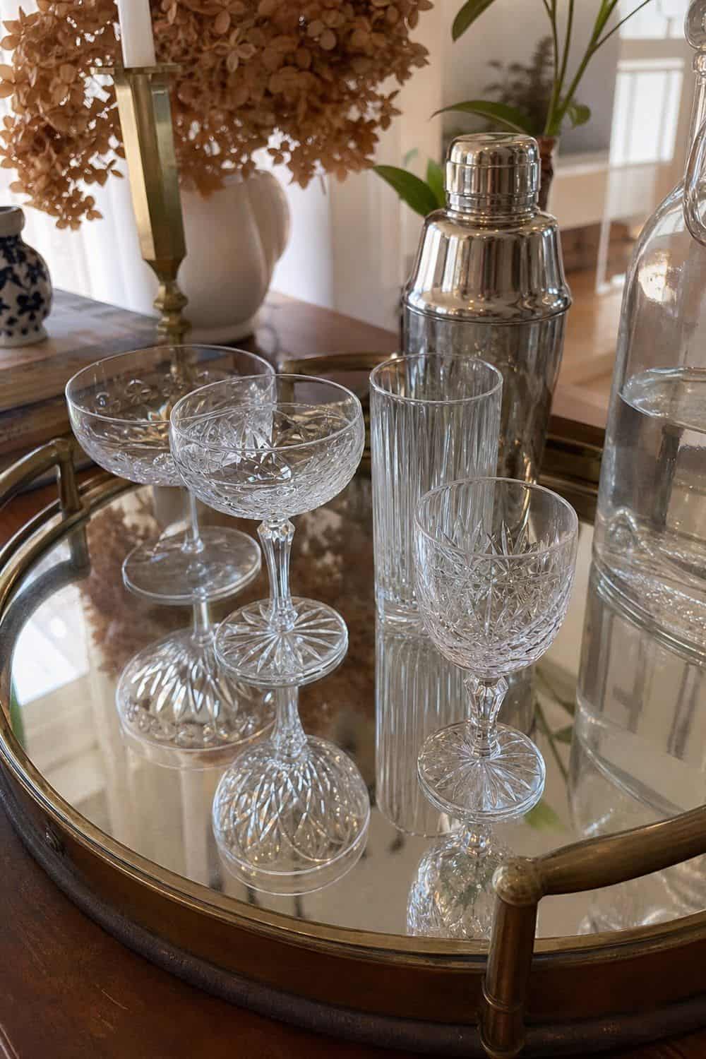 25 Neo Deco Tablescape Ideas for Easy Hosting Vintage Glassware Reflected Off a Tray in a casual Neo Deco tablescape