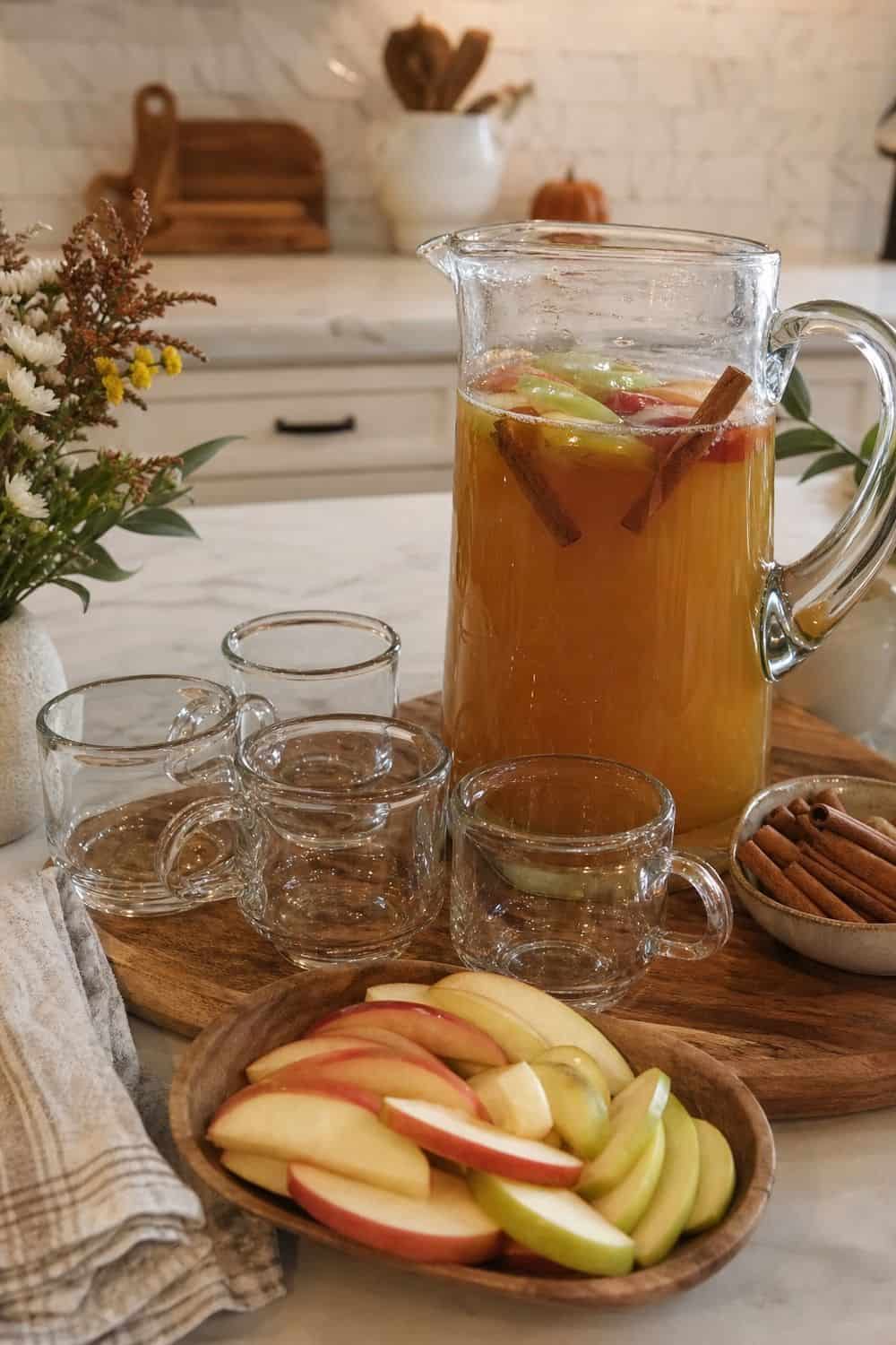 A zero-proof apple cider option with small cups and apple garnishes.