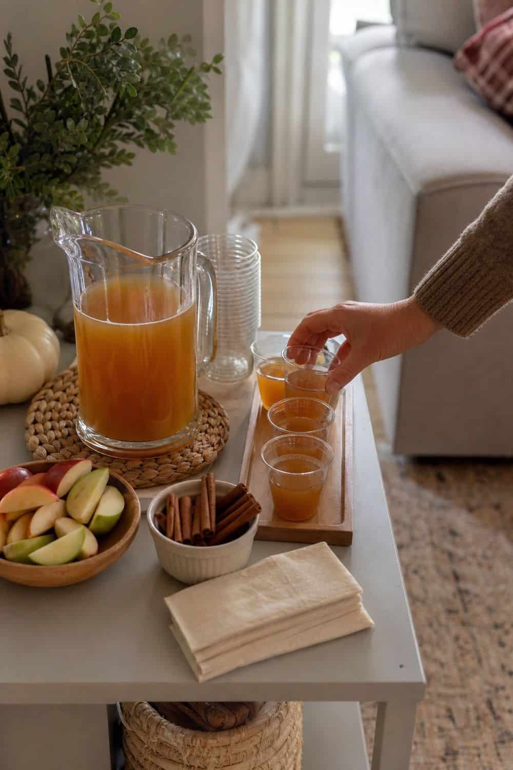 A child-friendly cider area with small cups, napkins, and apple slices.