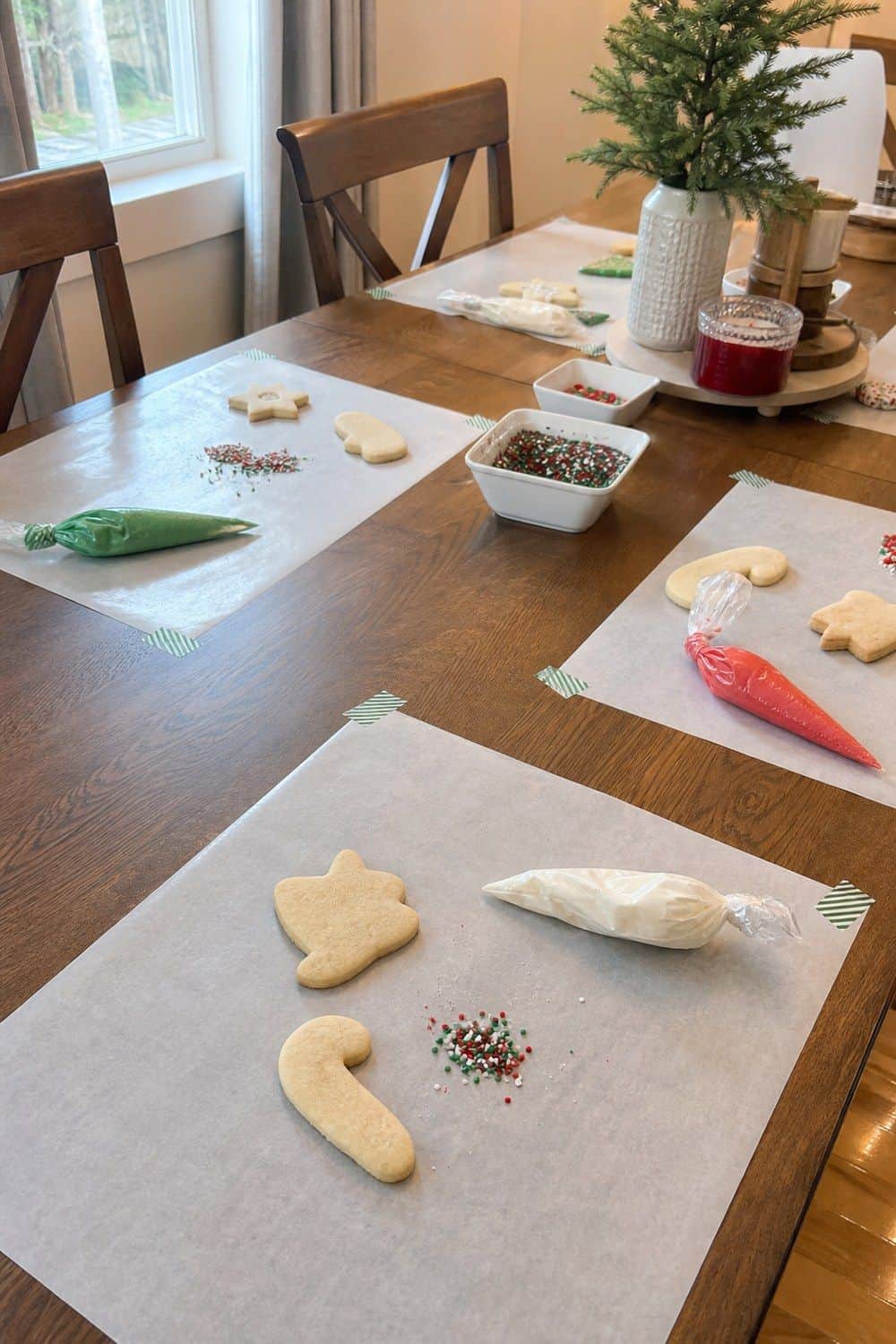25 Christmas Cookie Decorating Party Ideas for Easy Hosting Parchment for Table Protection setup for a Christmas cookie decorating party