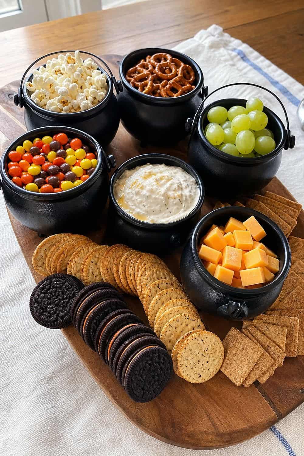 20 Halloween Treat Board Ideas for Cozy Food Moments 10. Witch Cauldron Snack Board Halloween treat board idea arranged on a cozy home table
