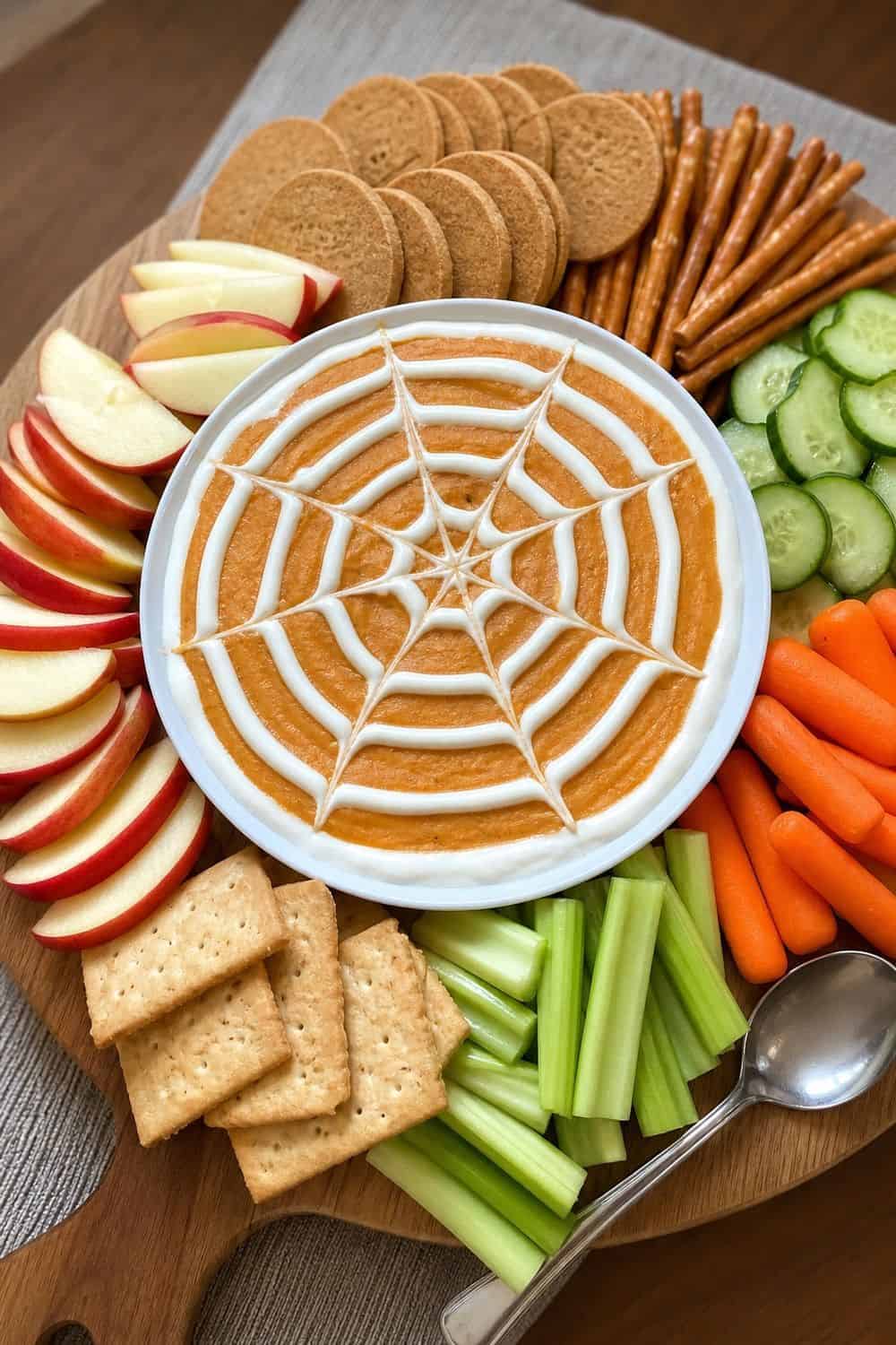 20 Halloween Treat Board Ideas for Cozy Food Moments 14. Spiderweb Dip Board Halloween treat board idea arranged on a cozy home table