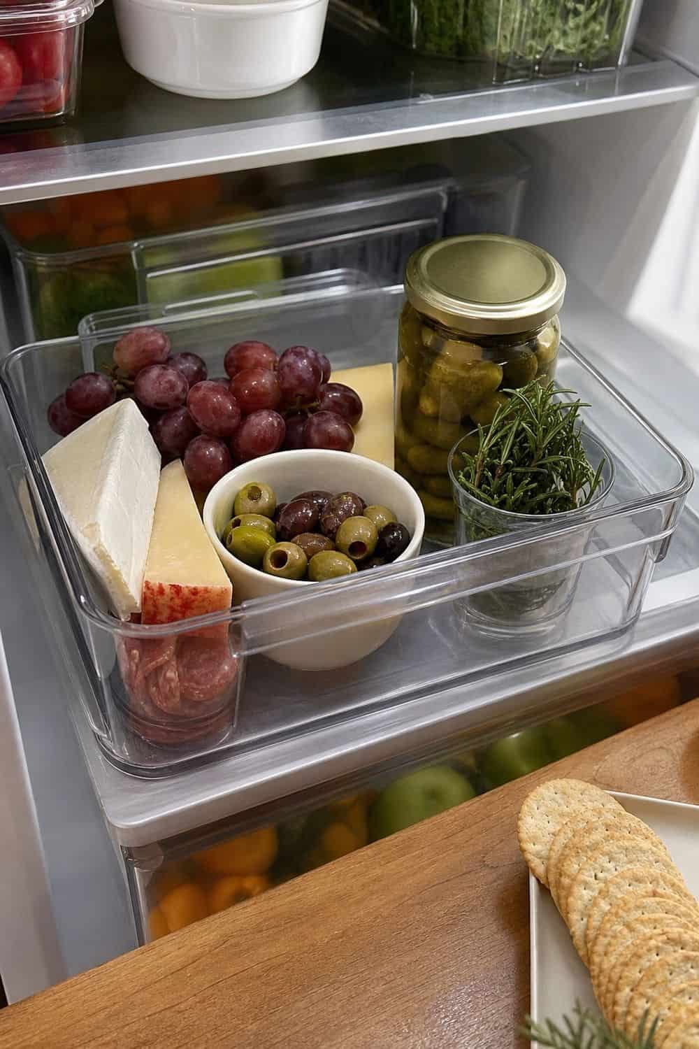 20 Holiday Fridge Ideas for Party Prep and Leftovers Holiday fridge idea showing reserve a small bin for cheese board ingredients.