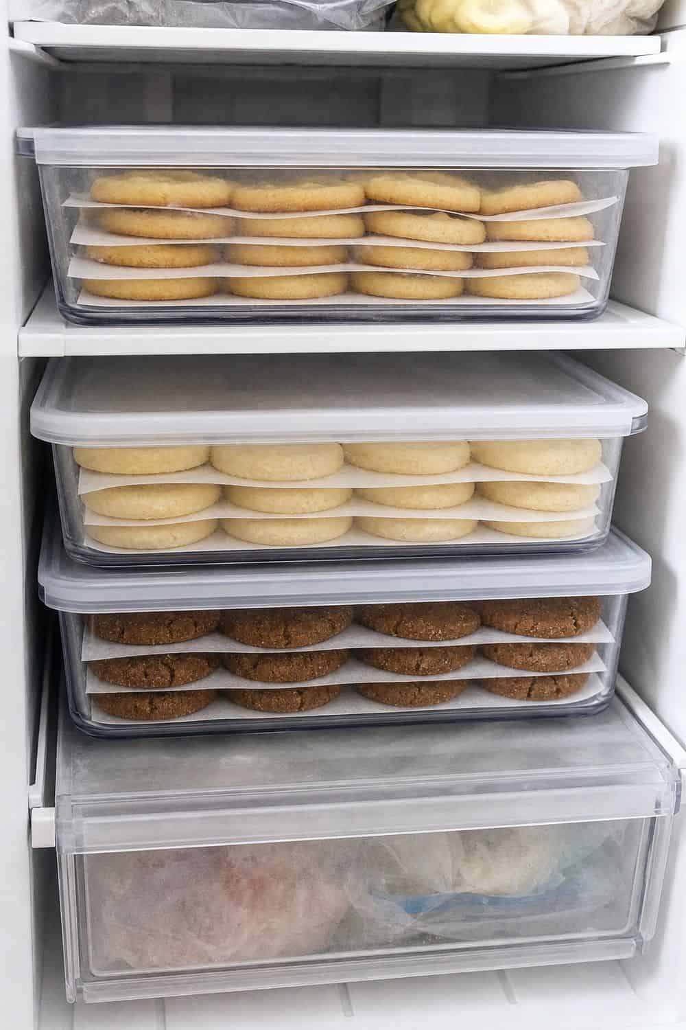 How to Store Holiday Cookies So They Stay Fresh Plain baked holiday cookies frozen in lidded containers with parchment layers.