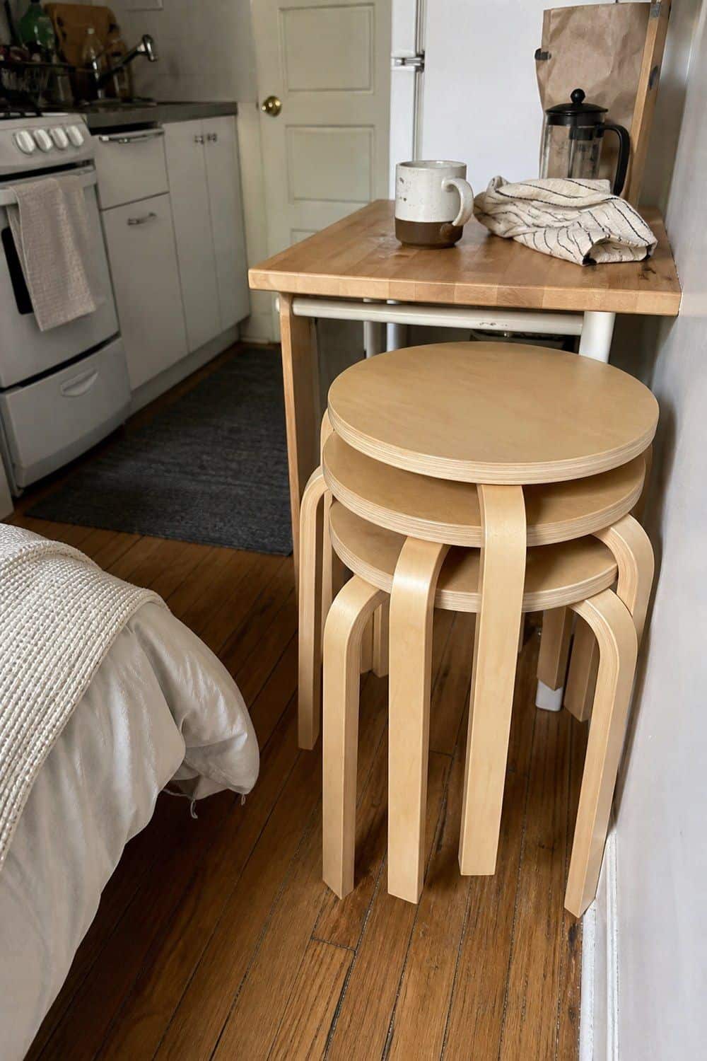 25 Studio Apartment Kitchen Ideas for Calm One-Room Living Stackable stools tucked under a small kitchen counter