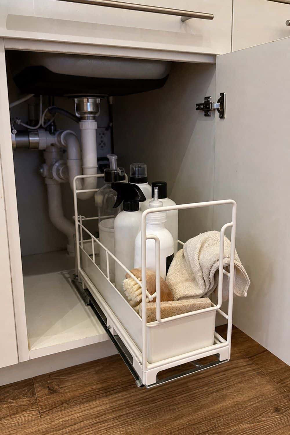 25 Studio Apartment Kitchen Ideas for Calm One-Room Living Pull-out caddy under a sink holding dish soap and sponges