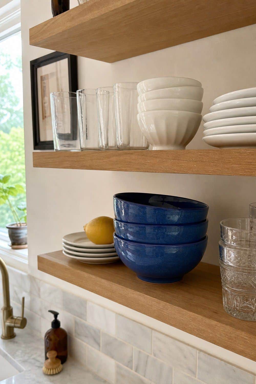 25 Summer Kitchen Decor Ideas for a Lighter Seasonal Look Aegean Blue Bowls on Open Shelves in a bright, realistic summer kitchen setting