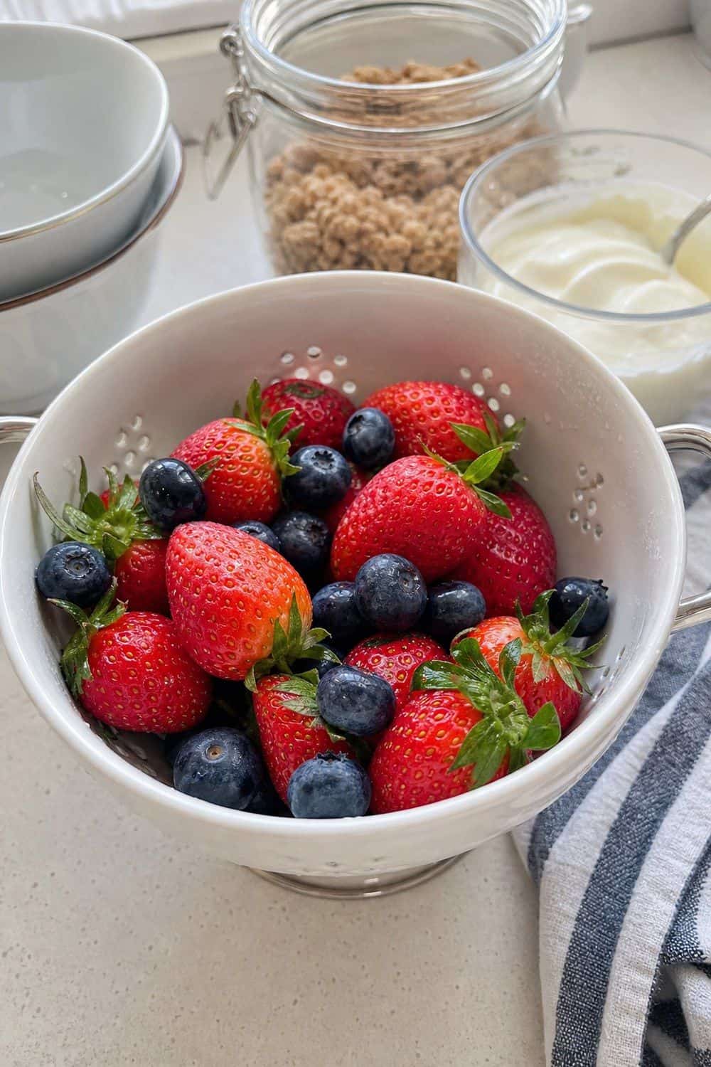 25 Summer Kitchen Decor Ideas for a Lighter Seasonal Look Berries in a Small Colander Bowl in a bright, realistic summer kitchen setting